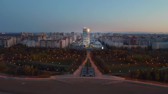 Beautiful evening city with a park and a skyscraper. Drone shooting.