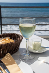 Summer holiday on sea, drinking white wine on outdoor terrace with sea view in sunny day