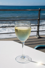 Summer holiday on sea, drinking white wine on outdoor terrace with sea view in sunny day