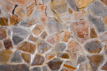 Texture of the wall made of granite stones. Construction, architecture, decoration.