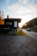Asphalt road and car with cloudy blue sky on the sunset background.