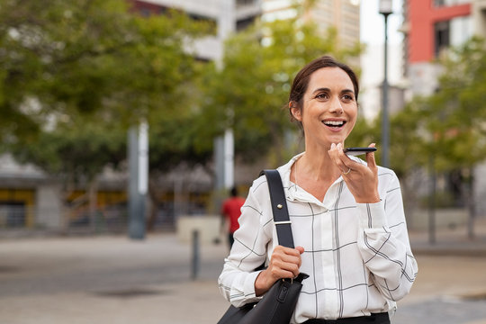 Business woman using speaker phone outdoor