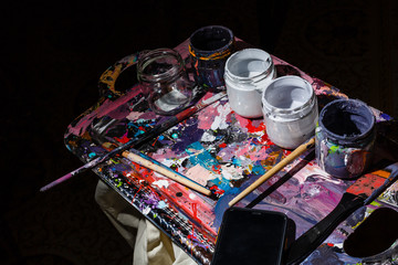 Artist workplace, blue and white paints, paint brushes on a palette