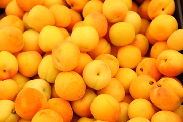 Lots of delicious looking very fresh peaches on sale at an outside market on a sunny Saturday.