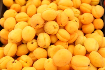 Lots of delicious looking very fresh peaches on sale at an outside market on a sunny Saturday.