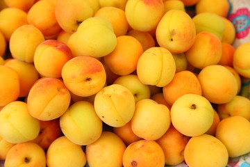 Lots of delicious looking very fresh peaches on sale at an outside market on a sunny Saturday.