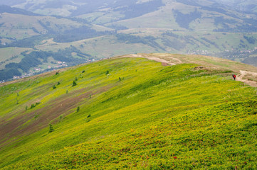 Beautiful mountain landscape with clouds. The road on the green top of Mount Ghimba in the Carpathians.