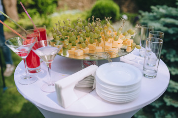 Wedding, festive banquet and buffet: canapes with cheese and grapes, alcohol, juice, dishes. Tasty treats, snack.