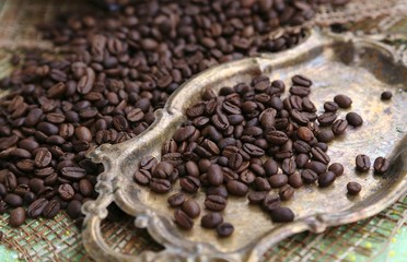Coffee in special roasting grains and shapes on the table and on the gold color tray