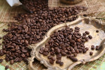 Coffee in special roasting grains and shapes on the table and on the gold color tray