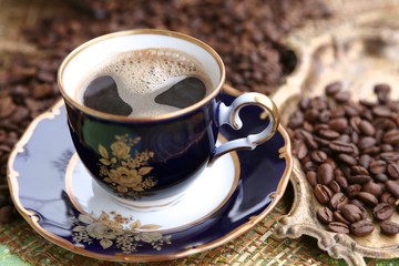 Package with coffee in grains cup with coffee with foam and coffee grains on the table