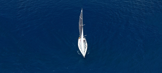 Aerial drone ultra wide photo of beautiful sailboat cruising in Aegean deep blue sea