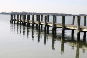 Fototapeta premium Old weathered wooden dock on a sandy coastal