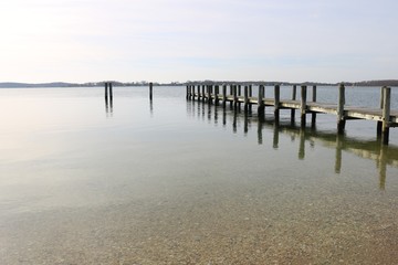 Old weathered wooden dock on a sandy coastal