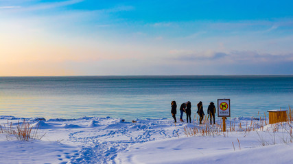A bunch of young people on a snowy beach