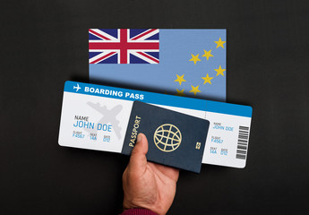 Hand holds passport and boarding pass with flag of Tuvalu 