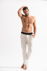 shirtless handsome man in white jeans on white