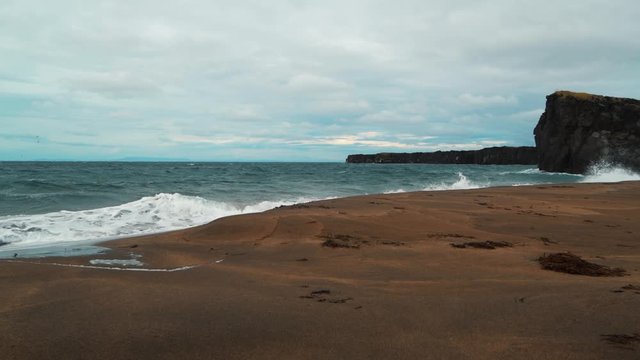 A rocky beach with volcanic basalt formations in West Iceland