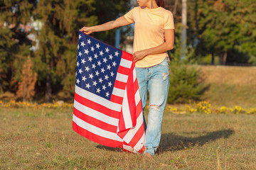 Woman with a flag of United States of America in the hand, outdoors