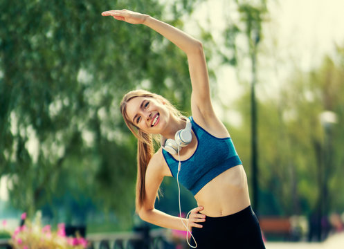 Portrait picture of happy smiling woman in sportswear doing fit exercise outdoor. Fitness, sport, exercising, crossfit and workout concept. Caucasian girl at training.