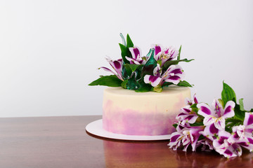 Fototapeta na wymiar Delicious beautiful cake is impregnated with tender cream, decorated with flowers.