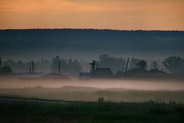 Fototapeta premium Russia. Republic Of Khakassia. Fog in the early summer morning in the fields near the city of Abakan.