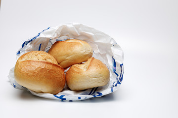 Drei braune helle Brötchen in einer Brötchen Tüte aus Papier auf weißen Hintergrund isoliert