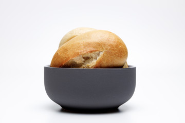 Frische helle Weizenbrötchen in einer dunkel Grauen schale auf Weißen Hintergrund isoliert