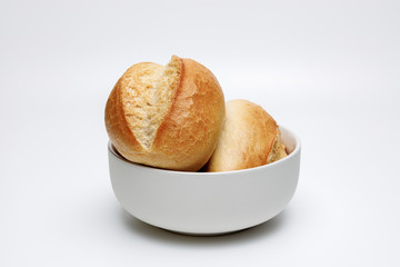 Frische helle Weizenbrötchen in einer dunkel weißen schale auf Weißen Hintergrund isoliert