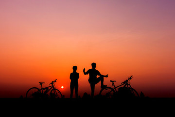 Plakat colorful of family cyclist and Bicycle silhouettes on the dark background of sunsets