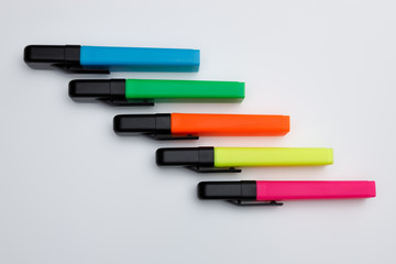Textmarker oder Highlighter in blau, rot, gelb, neon, pink und grün mit aufgesteckten Schwarzen Kappen, geschlossen isoliert, seitlich. Sehr gut geeignet um kreative Ideen auf das Papier zu bekomme.