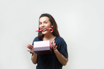 Portrait of a happy smiling girl opening a gift box isolated over white background