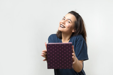 Portrait of a happy smiling girl opening a gift box isolated over white background