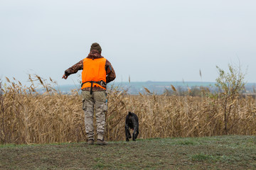 Hunting period, autumn season open. A hunter with a gun in his hands in hunting clothes in the...
