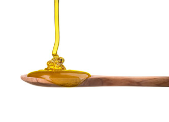 Falling and flowing honey on a wooden spoon isolated on white with clipping path