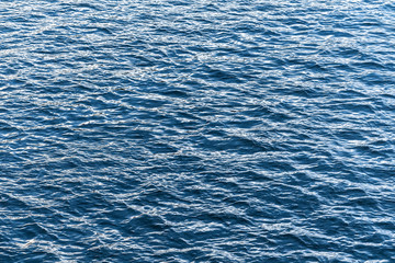 Blue water surface. Background texture photo of a water, river or sea. Clear wawing water surface.