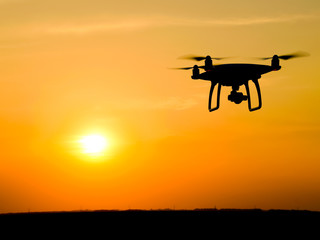 Quadrocopters silhouette against the background of the sunset