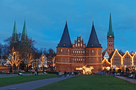 Blick auf die Altstadt von L&uuml;beck mit dem Holstentor, der Marienkirche (links), der Petrikirche und historischen Salzspeichern zu Weihnachten