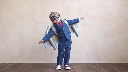 Happy child with toy paper wings. Slow motion