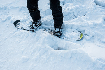 cropped view of snowboarder riding on white snow in winter