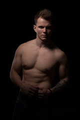 Fototapeta premium portrait of a beautiful fashionable strong man with a bare torso