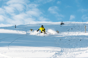 sportsman in helmet holding ski sticks while skiing on slope outside