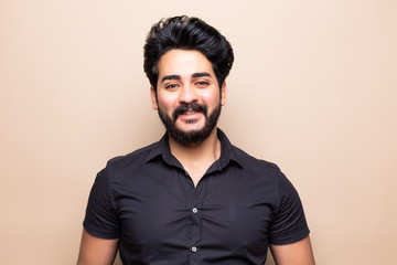 Obraz premium Young bearded man standing isolated on beige background