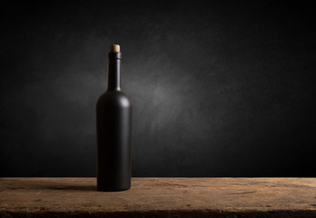 Wine tasting experience in the rustic cellar and wine bar: red wine glass and collection of excellent wines on the background