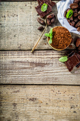 Different conditions of cocoa. Various cocoa - beans, beans, ground, crushed cocoa powder, chocolate paste, chocolate pieces and hot chocolate in a cup. On a wooden rustic background with copy space f