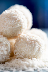 Homemade round candy made from coconut flakes and white chocolate close-up. Set candy truffles snowball, selective focus