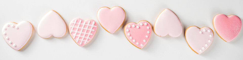 Homemade pick sugar glazed Valentine day cookies. Valentine heart shaped bakings. White stone...