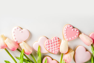 Homemade pick sugar glazed Valentine day cookies. Valentine heart shaped bakings. White stone background copy space top view