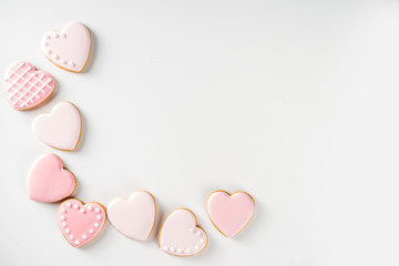 Homemade pick sugar glazed Valentine day cookies. Valentine heart shaped bakings. White stone background copy space top view