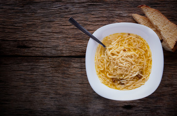 Chicken soup on a rustic wooden table